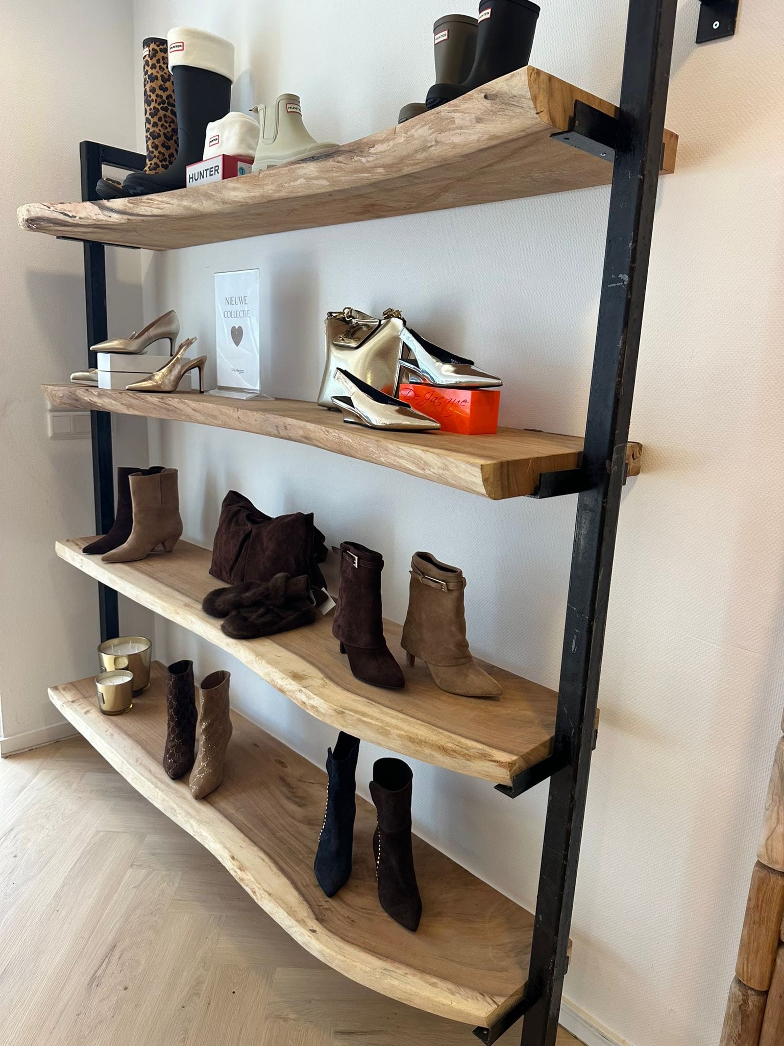 Stiefel und Pumps auf vier Suar-Bohlen in einem Stahlregal