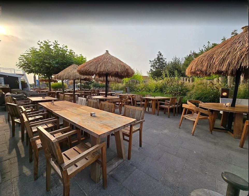 Terrasse mit Schilfschirmen und Holzmöbeln