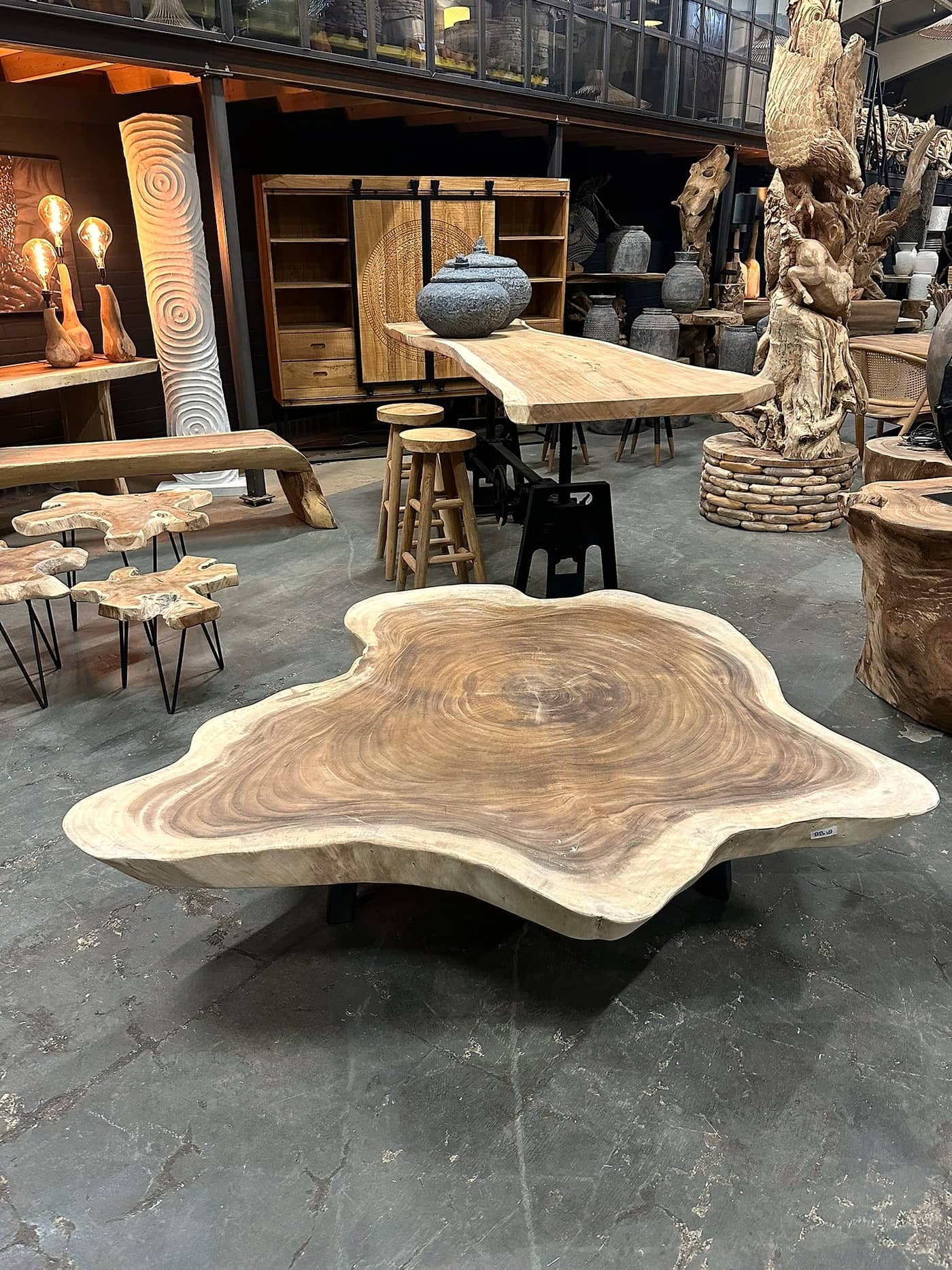 Salontafel van suarhout met een organisch gevormd blad op ijzeren poten, in de showroom