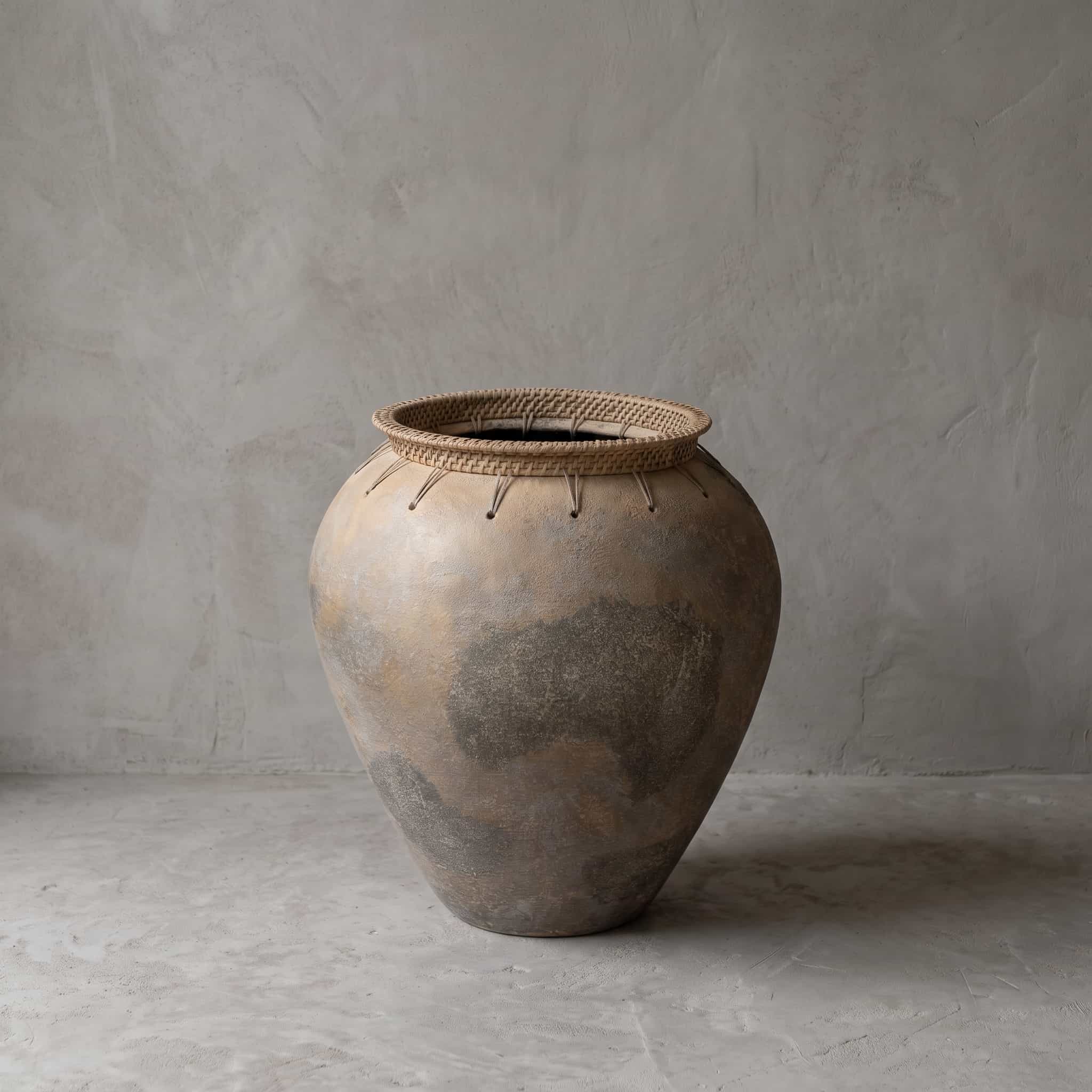 Pot Guci Tity van terracotta, vooraanzicht van de bolle pot met een gevlochten band rond de opening