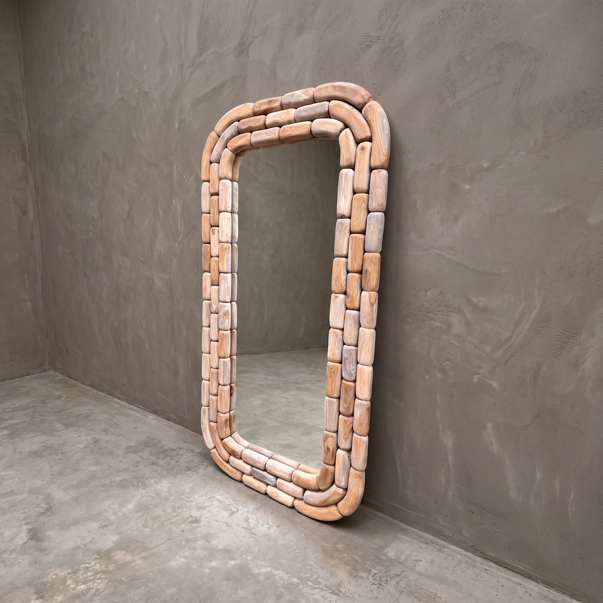 Spiegel Arunja van gerecycled teak, 180 cm hoog, schuin van voren gezien, met een lijst van afgeronde blokjes tegen een grijze wand