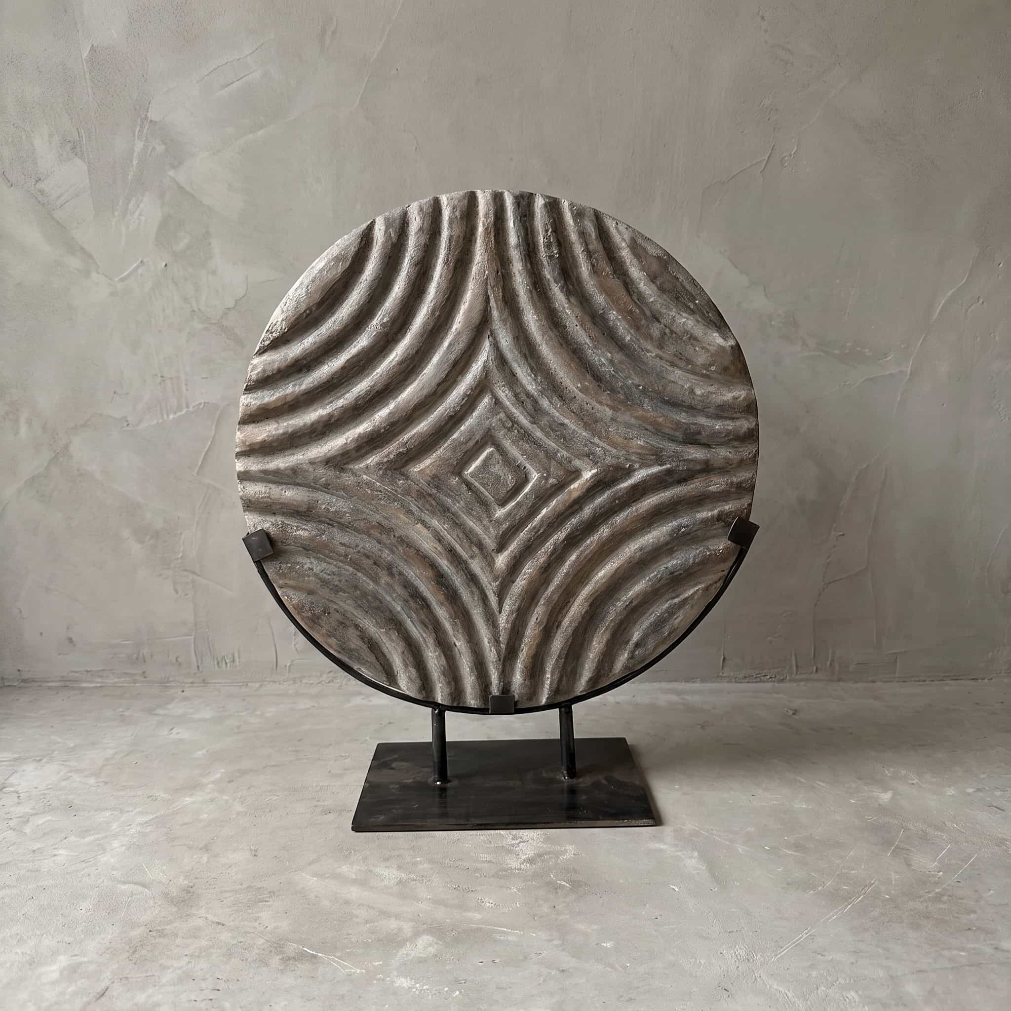Sokkel Melengkung van polystone, vooraanzicht van de ronde schijf met gebogen ribbels in een zwarte beugel