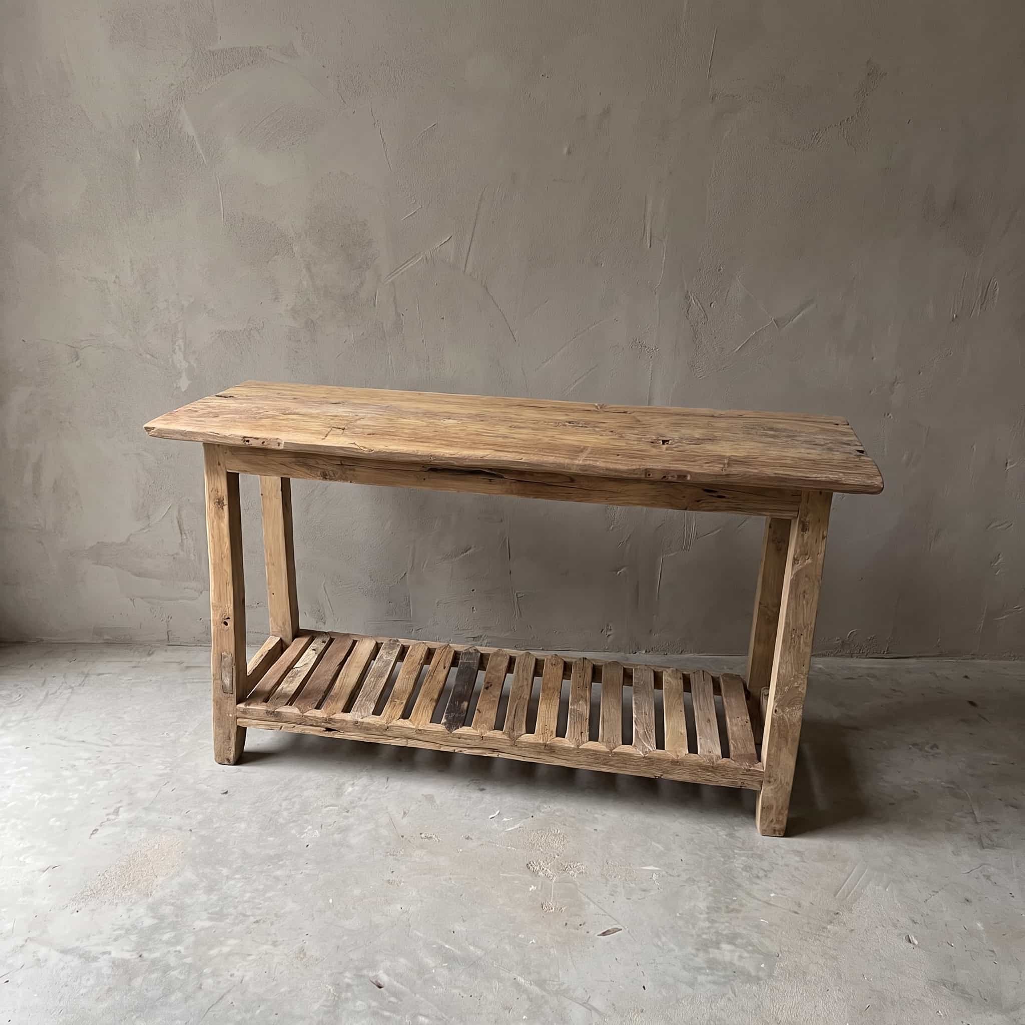 Bijzettafel Rayhan van teak, vooraanzicht van het lange blad van planken met een onderblad van latten tussen de poten