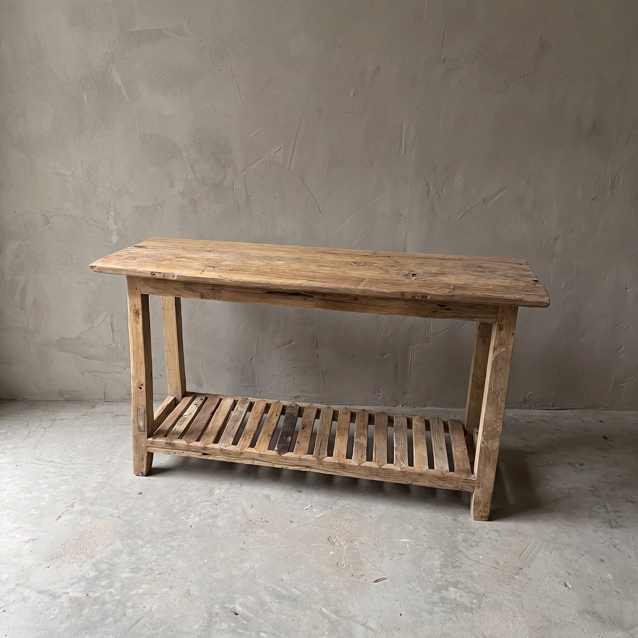 Bijzettafel Rayhan van teak, vooraanzicht van het lange blad van planken met een onderblad van latten tussen de poten