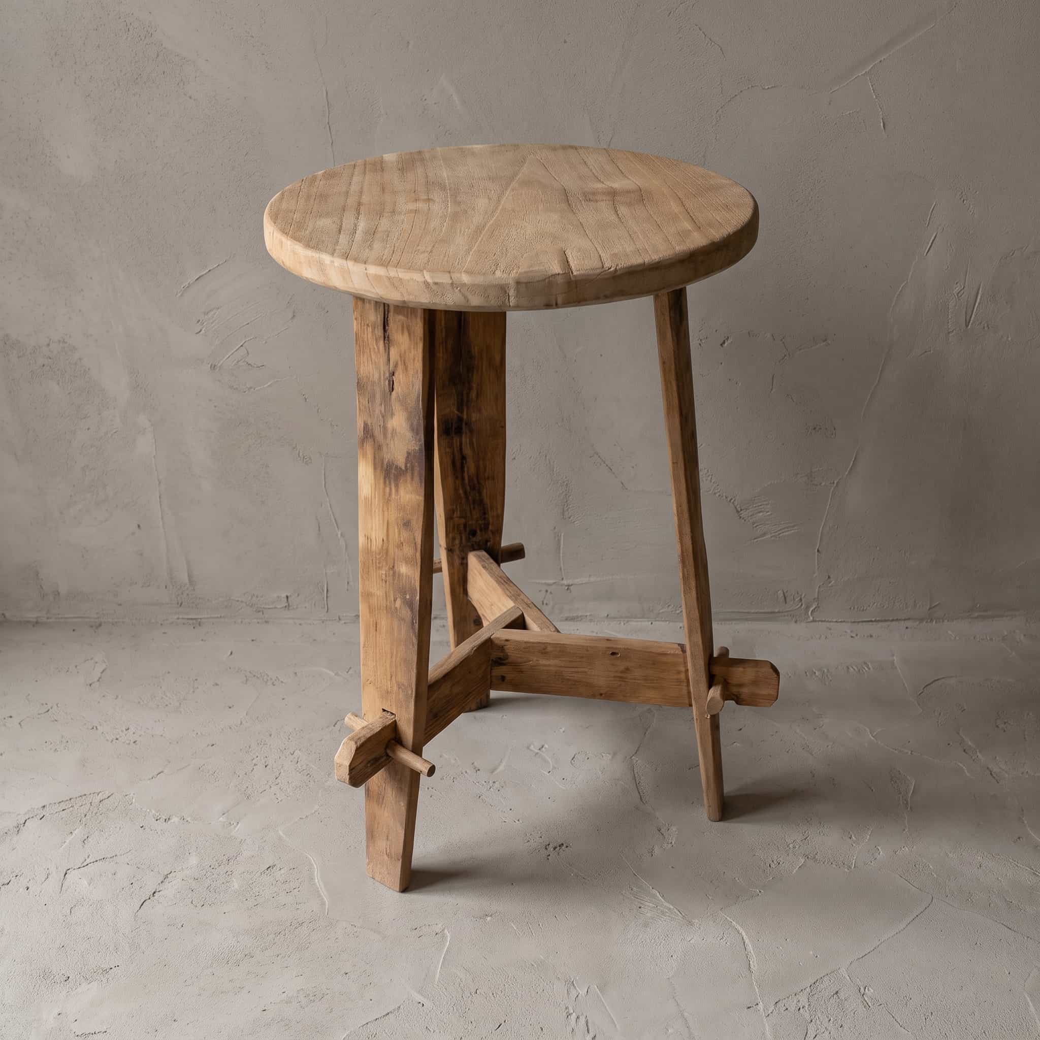 Bijzettafel Beben van teak, schuin van boven gezien, met het ronde blad op drie poten en pennen in de dwarsbalken