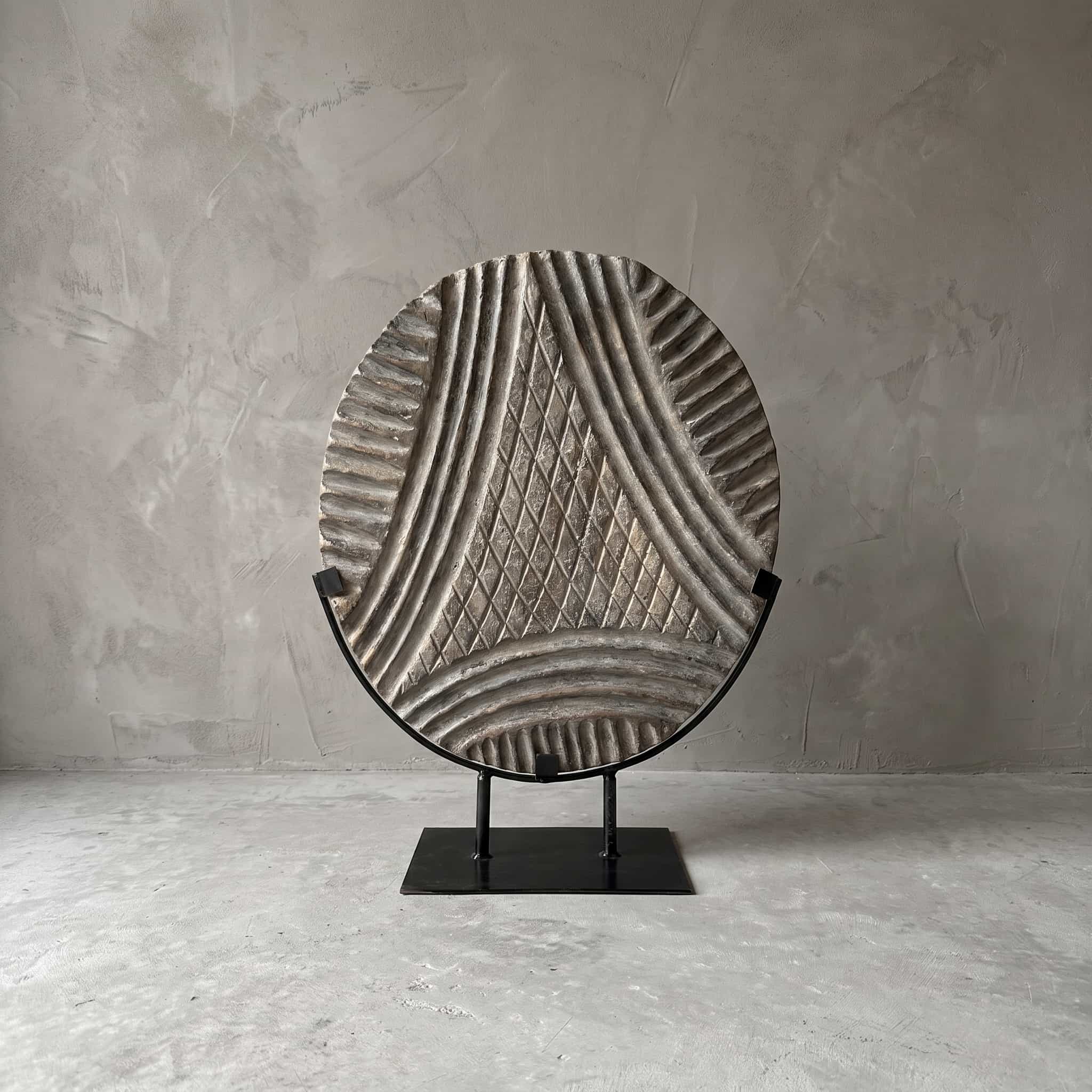 Sokkel Wajik van polystone, vooraanzicht van de schijf met een driehoek in ruitjespatroon in een zwarte beugel