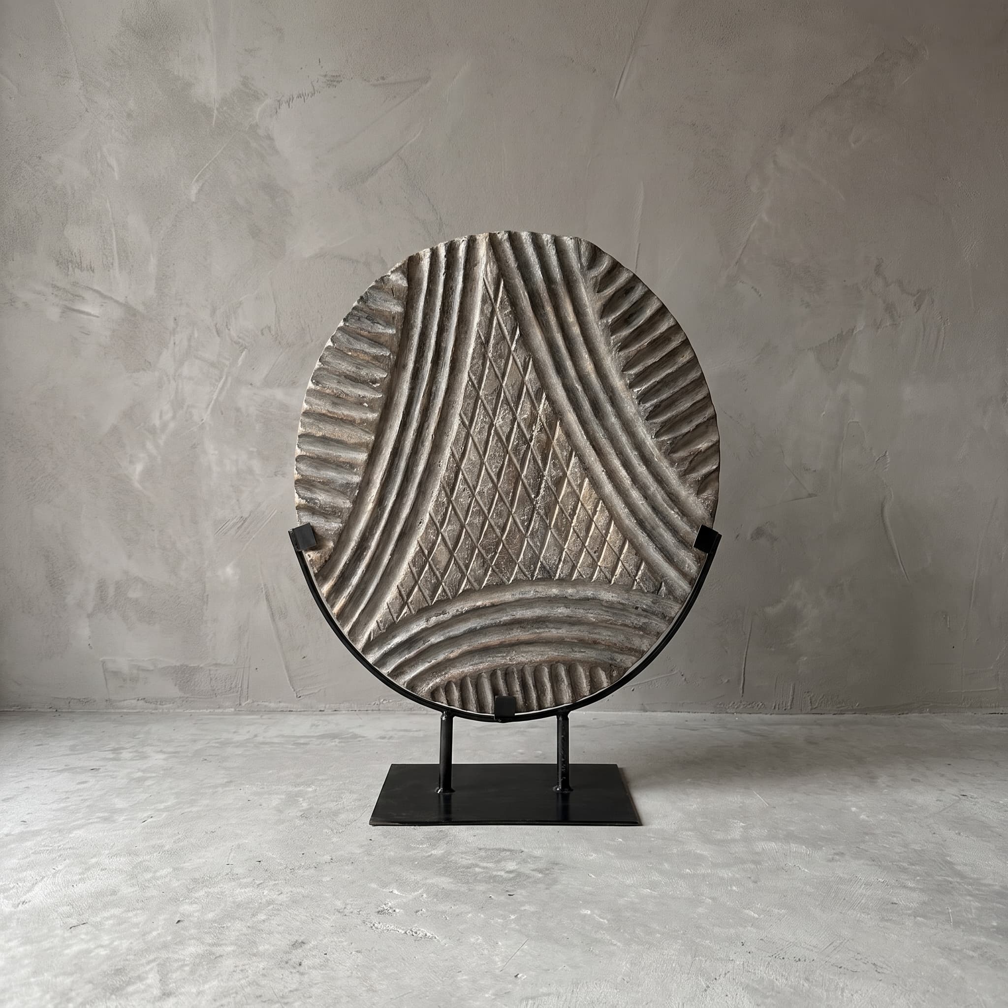 Sokkel Wajik van polystone, vooraanzicht van de schijf met een driehoek in ruitjespatroon in een zwarte beugel
