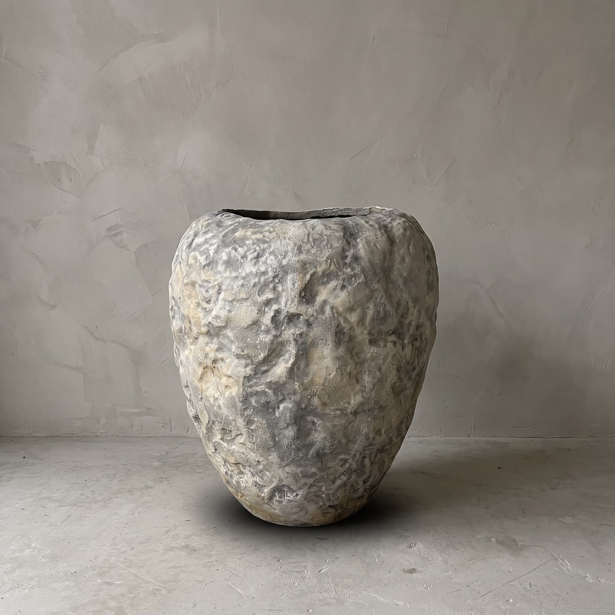 Pot van polystone, guavevorm, lichtgrijs, vooraanzicht van de pot met bobbelig oppervlak en ronde schouder voor een grijze wand