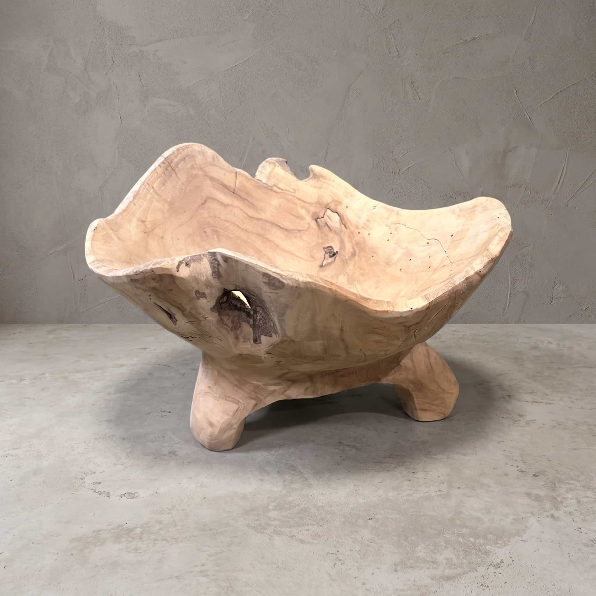 Schaal Supri van gerecycled teak, vooraanzicht van de golvende rand en de korte poten, voor een grijze wand