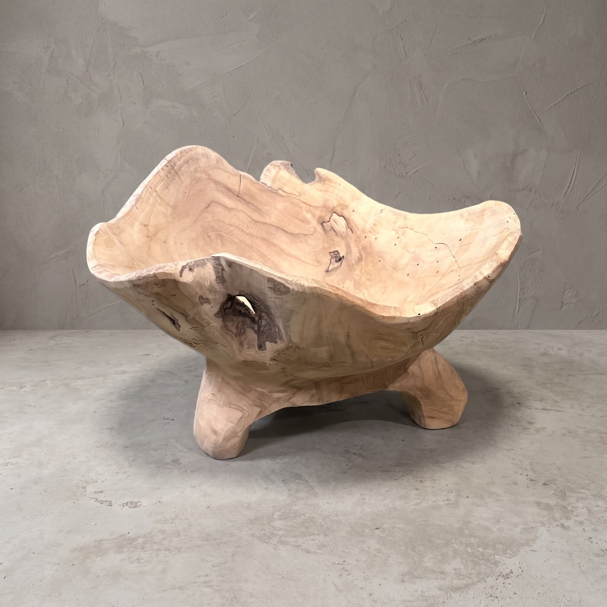 Dekoschale Supri aus recyceltem Teak, Vorderansicht mit geschwungenem Rand und kurzen Füßen vor grauer Wand