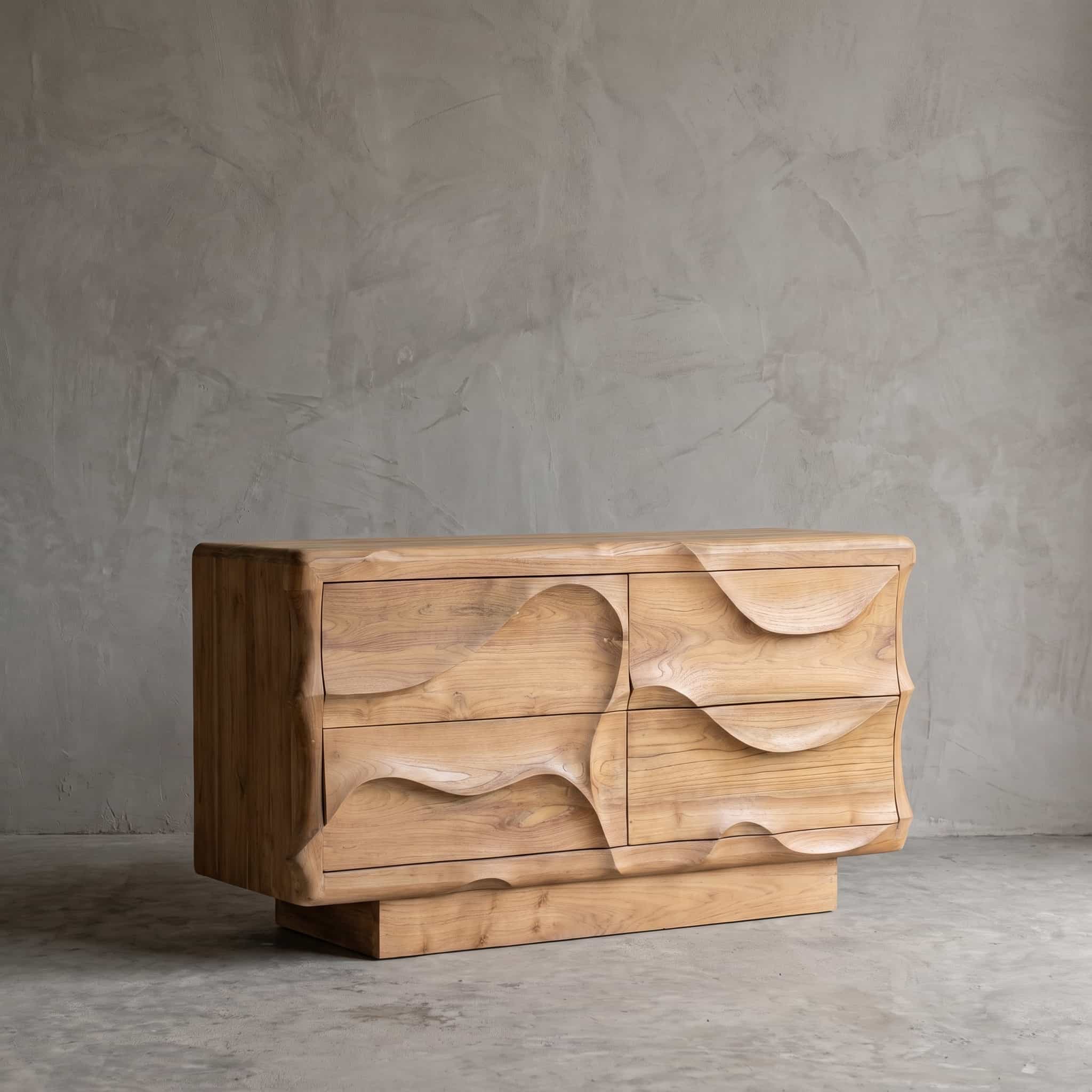 Dressoir Wave van teak, 4 lades, schuin vooraanzicht van het golvende reliëf op een smallere onderbouw
