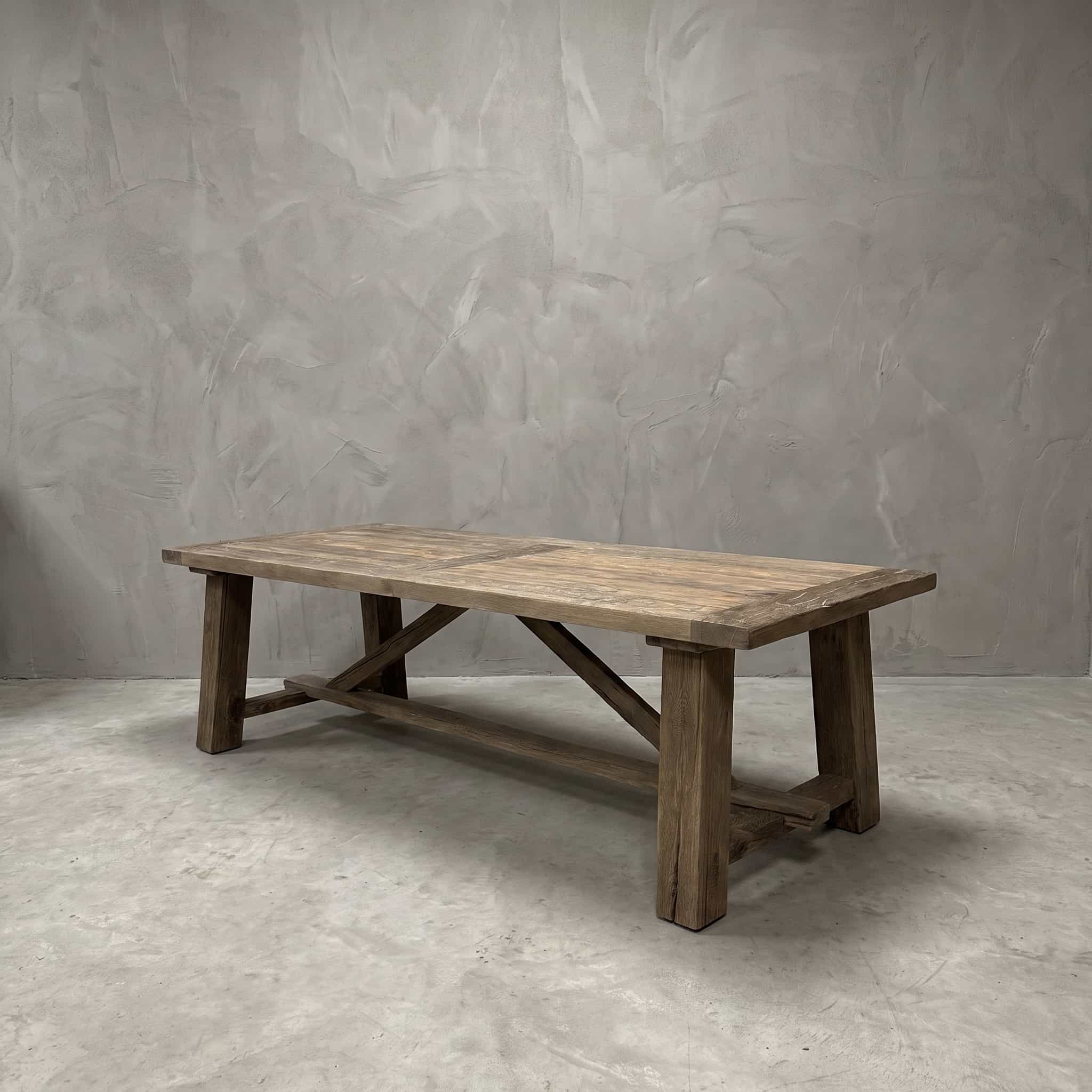 Eettafel Freya van gerecycled eikenhout, vooraanzicht van het plankenblad op vier vierkante poten met schuine balken