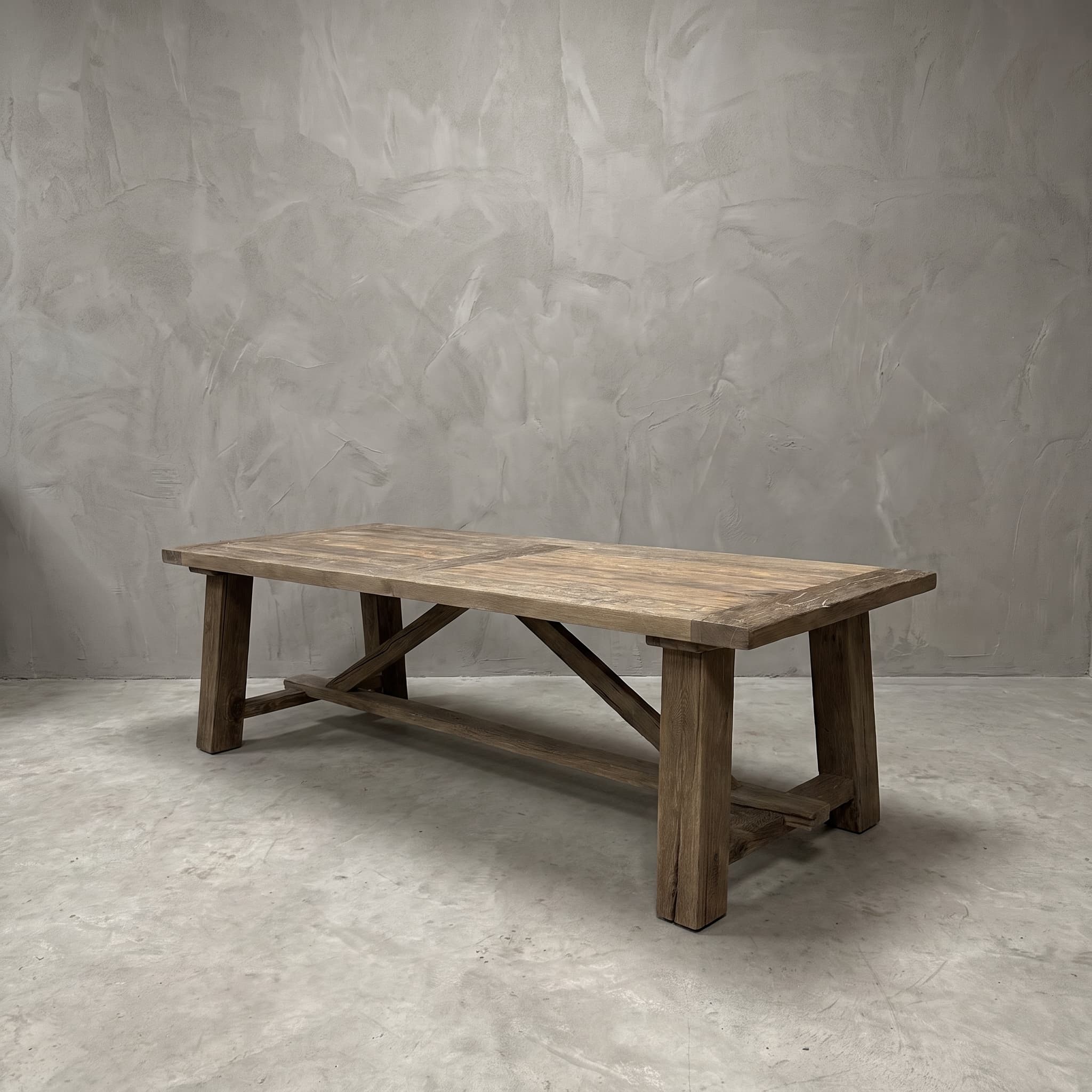 Eettafel Freya van gerecycled eikenhout, vooraanzicht van het plankenblad op vier vierkante poten met schuine balken