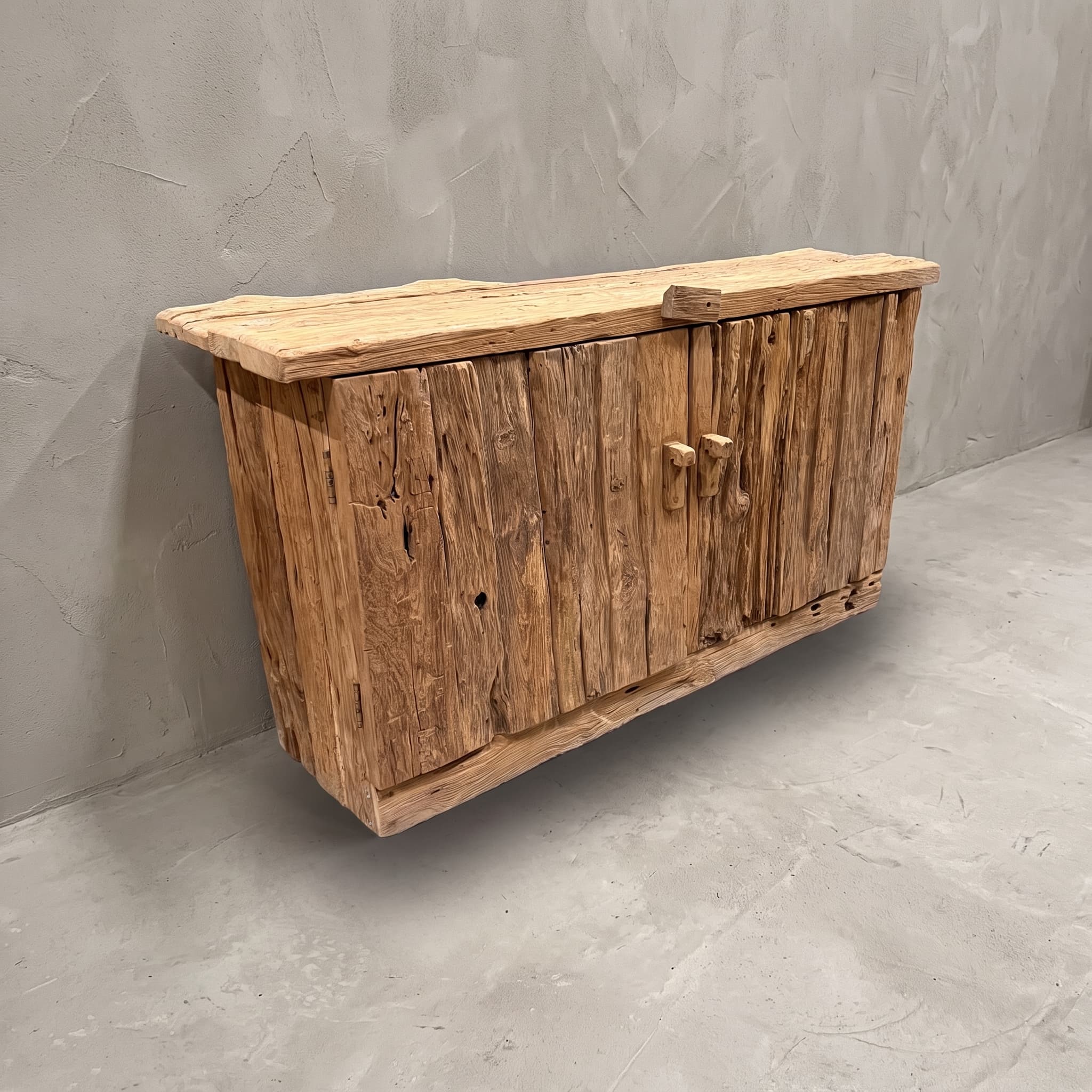 Dressoir Rayhan Erosi van teak, schuin vooraanzicht van twee deuren met ruwe, verticale planken onder een dik blad
