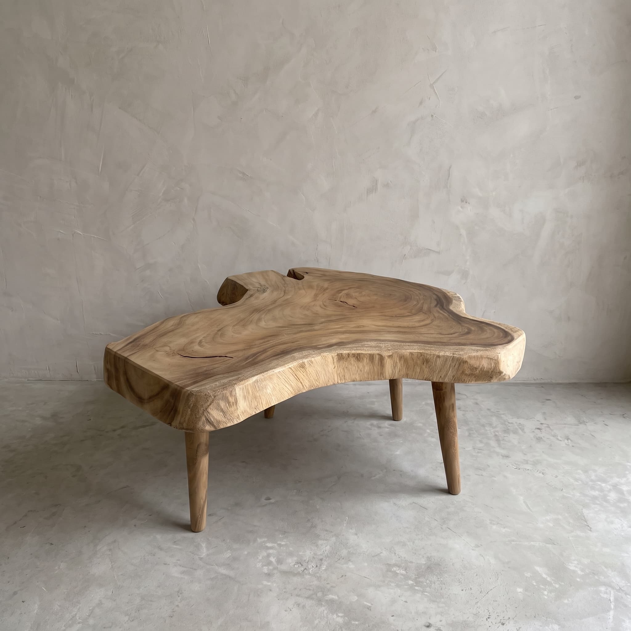 Salontafel van suarhout, met houten poten, 100 cm, schuin aanzicht van de grillige boomschijf met jaarringen op vier taps toelopende poten