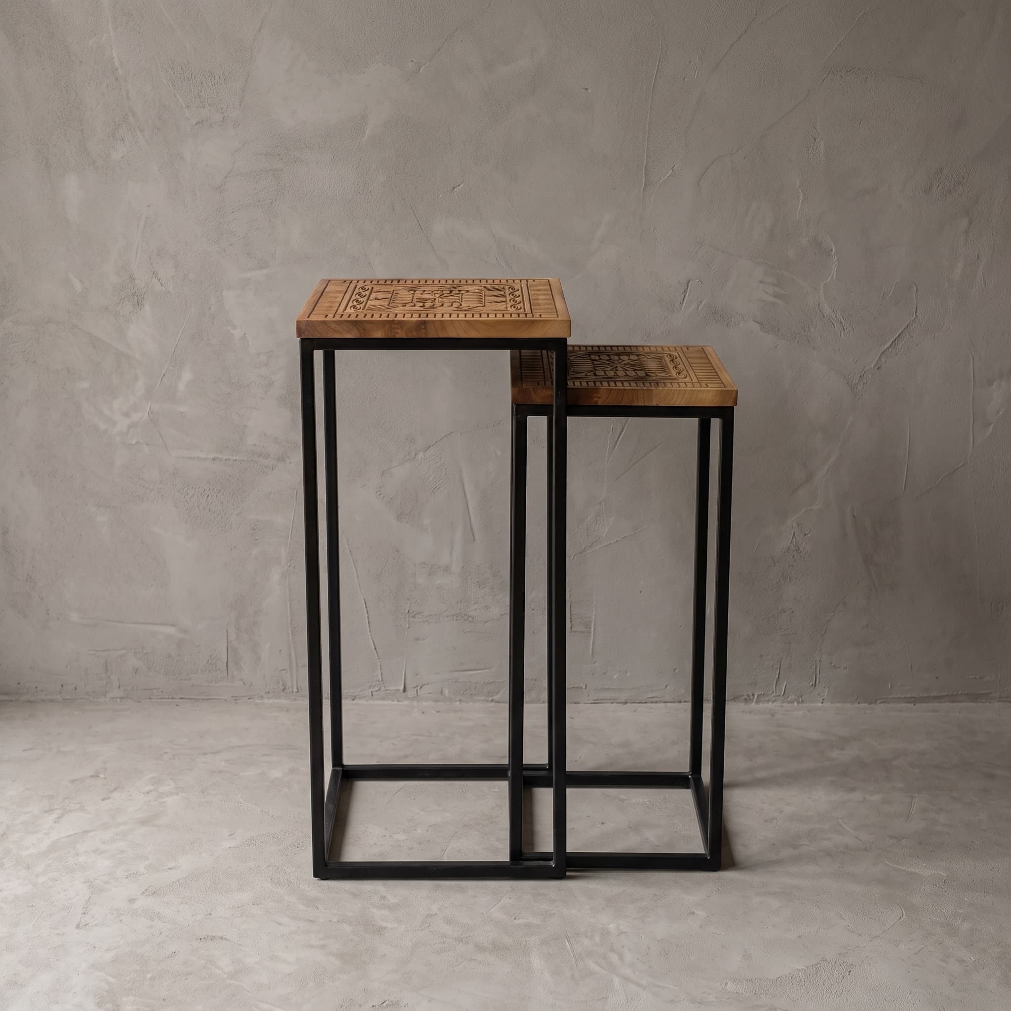 Intan teak display, set of 2, front view: the lower piece stands to the right behind the taller one, against a grey wall