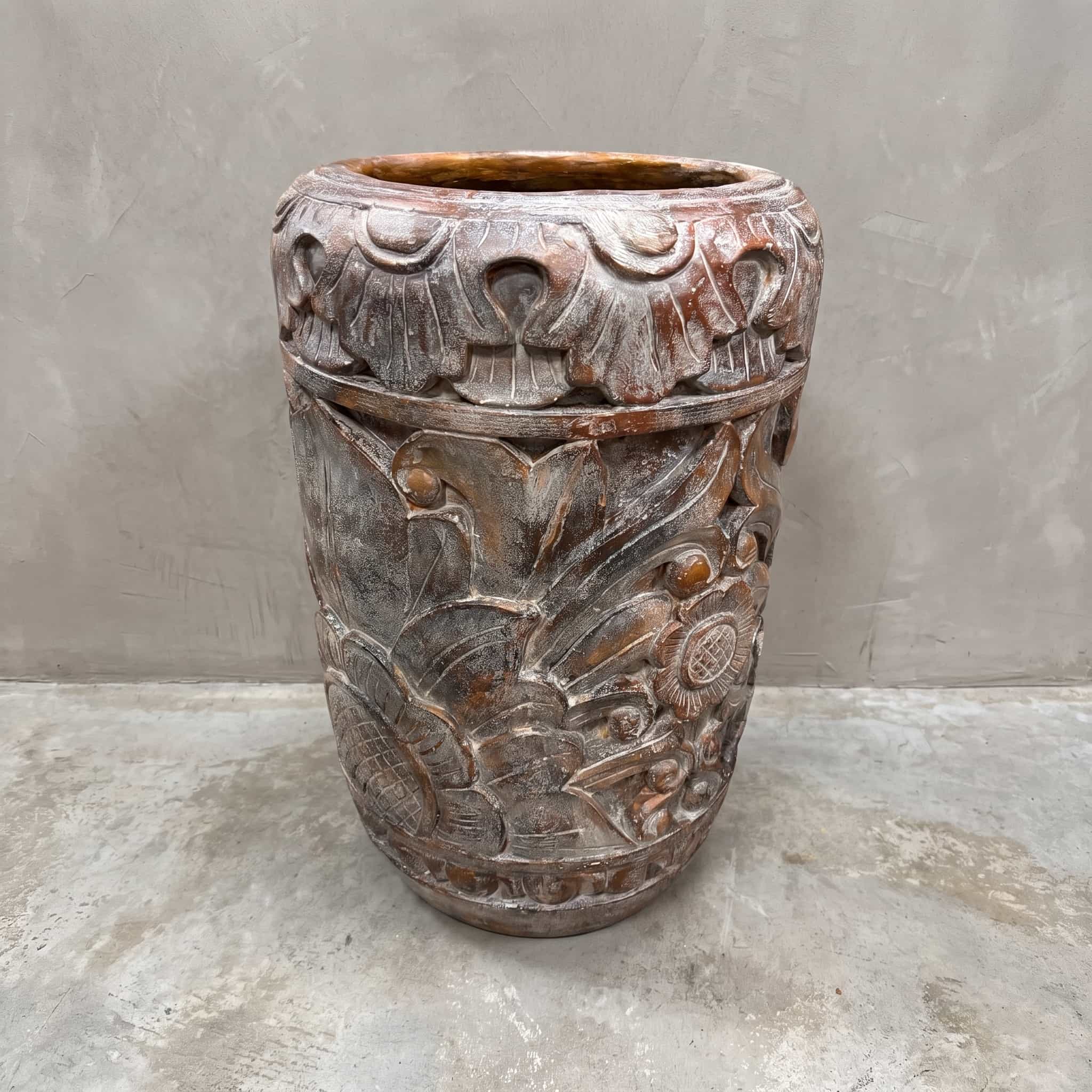 Pot Matahari van polystone, vooraanzicht met bloemen in reliëf en een band van waaiervormige motieven bovenaan