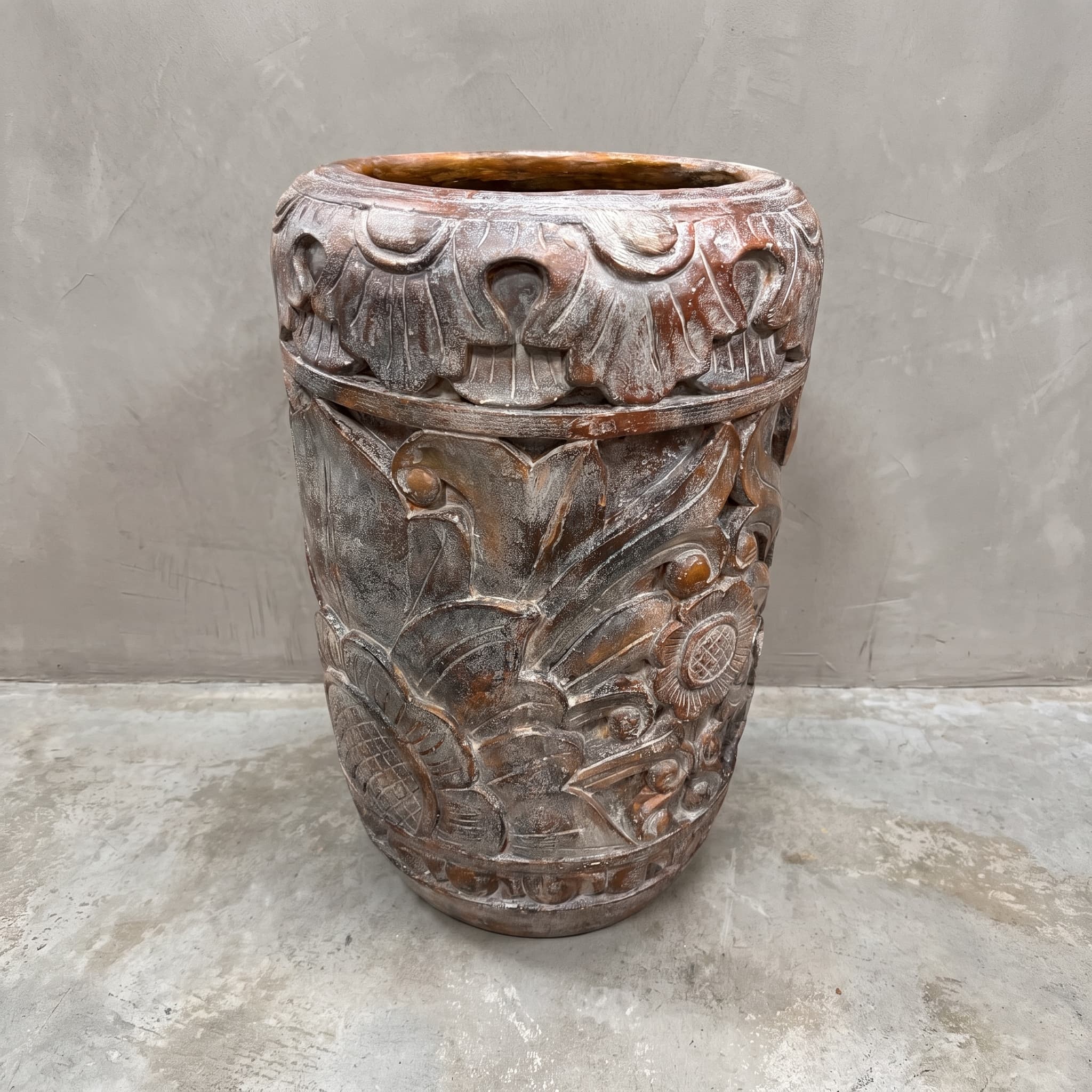 Pot Matahari van polystone, vooraanzicht met bloemen in reliëf en een band van waaiervormige motieven bovenaan