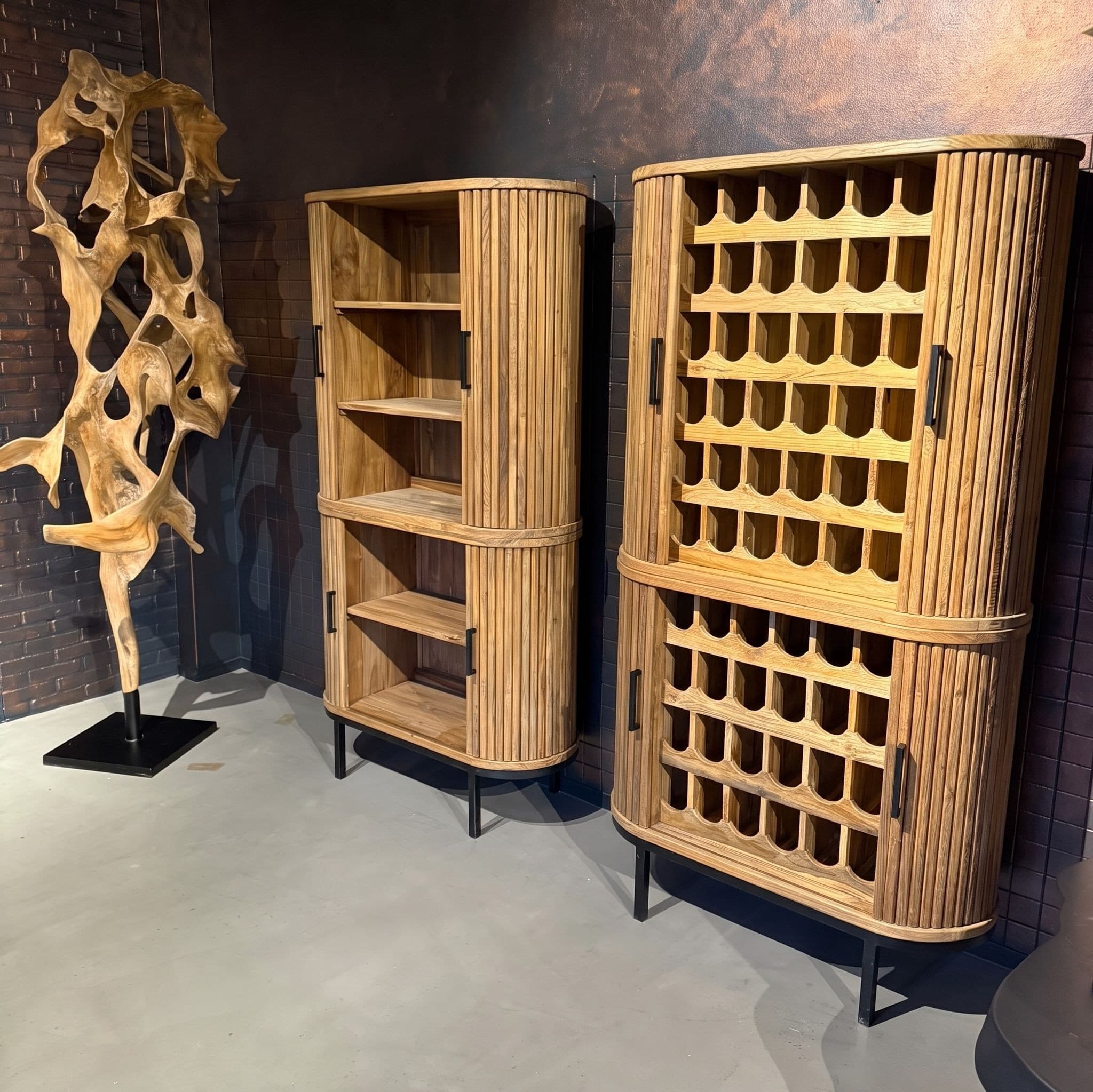 Kast Krepyak van gerecycled teak, wijnrek, in de showroom naast een open kast met dezelfde geribbelde, ronde zijkanten