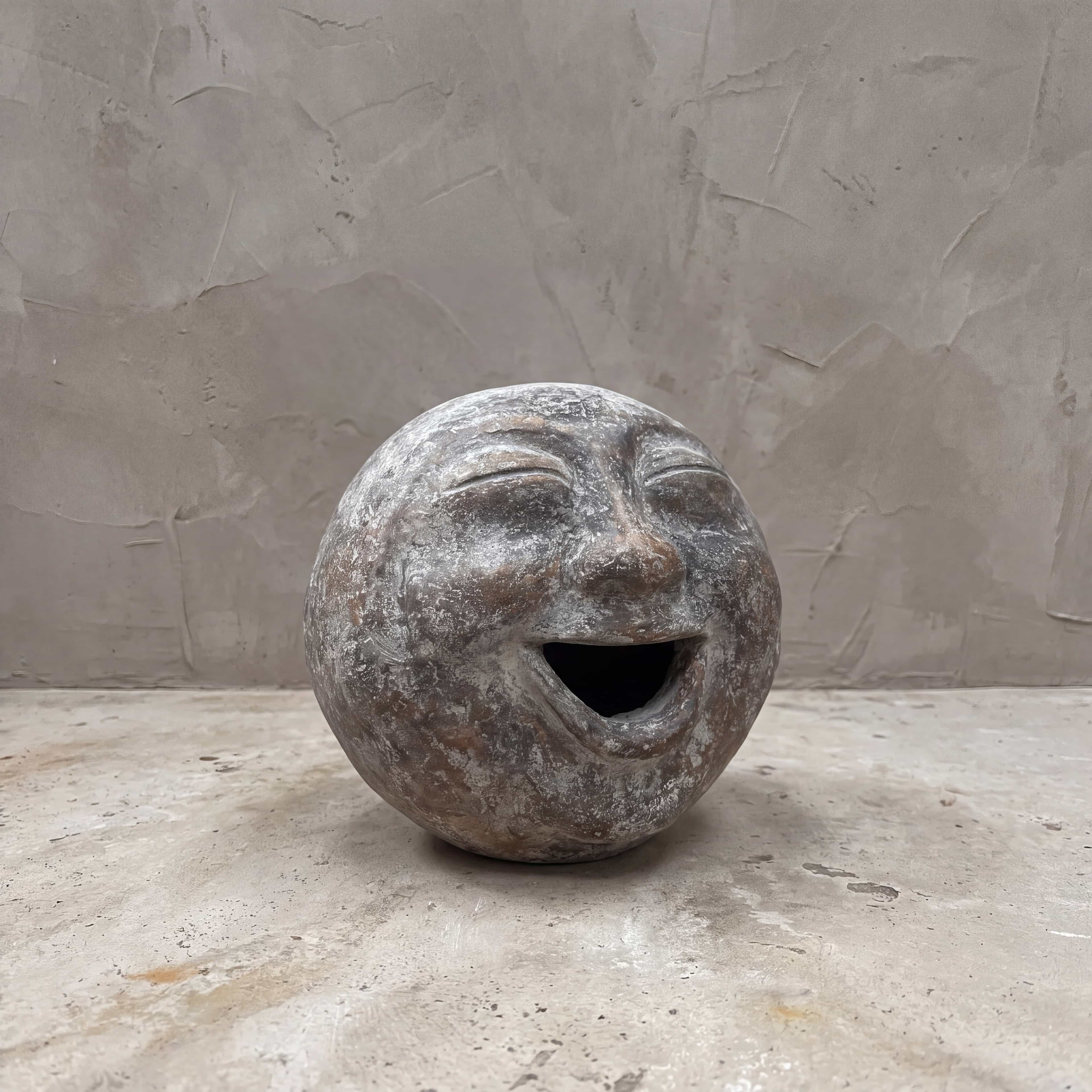 Beeld Moon van polystone, lachend, vooraanzicht van de bol met gesloten ogen en een wijd open mond
