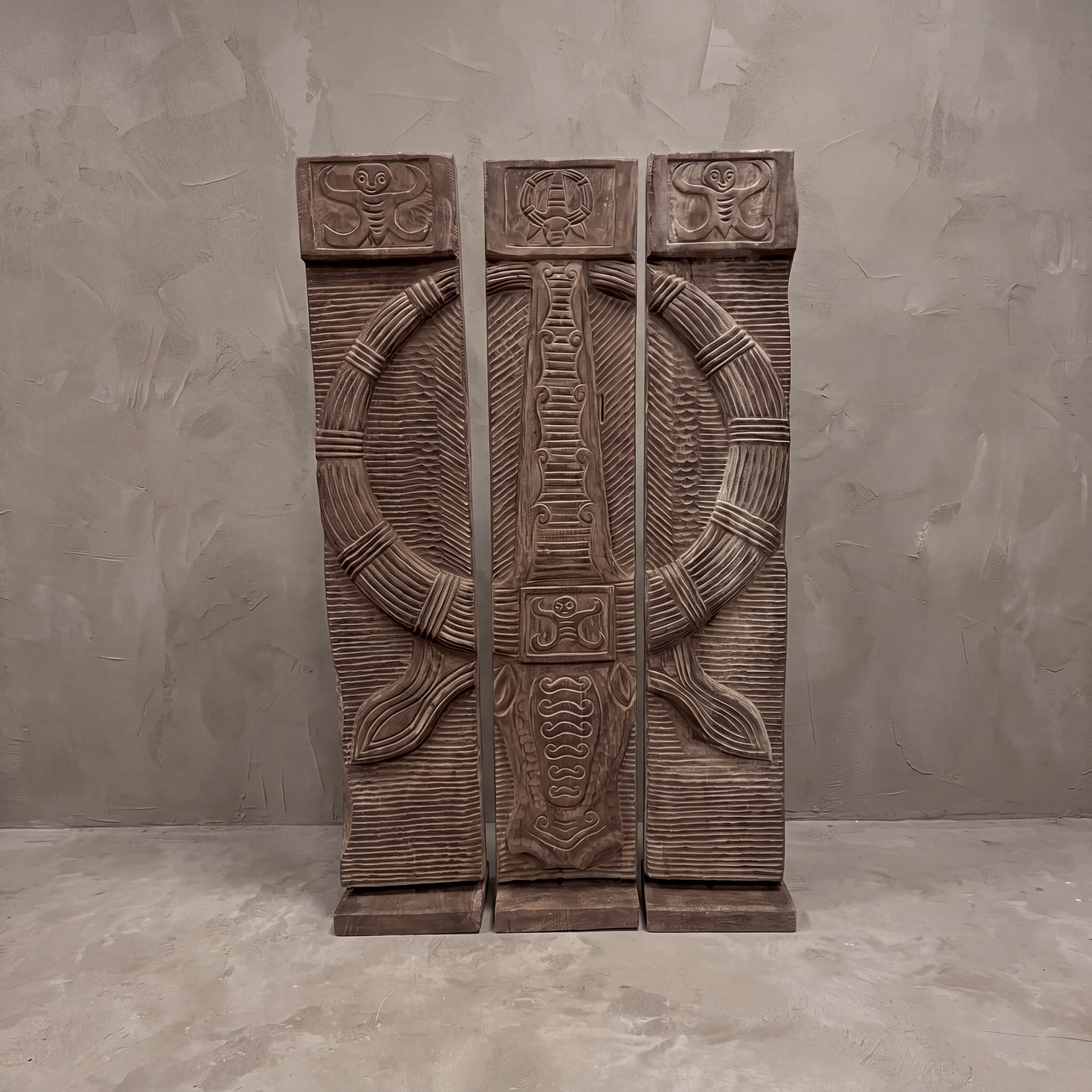 Roomdivider Toraja van suarhout recht van voren, met de figuren in reliëf op de blokken bovenaan