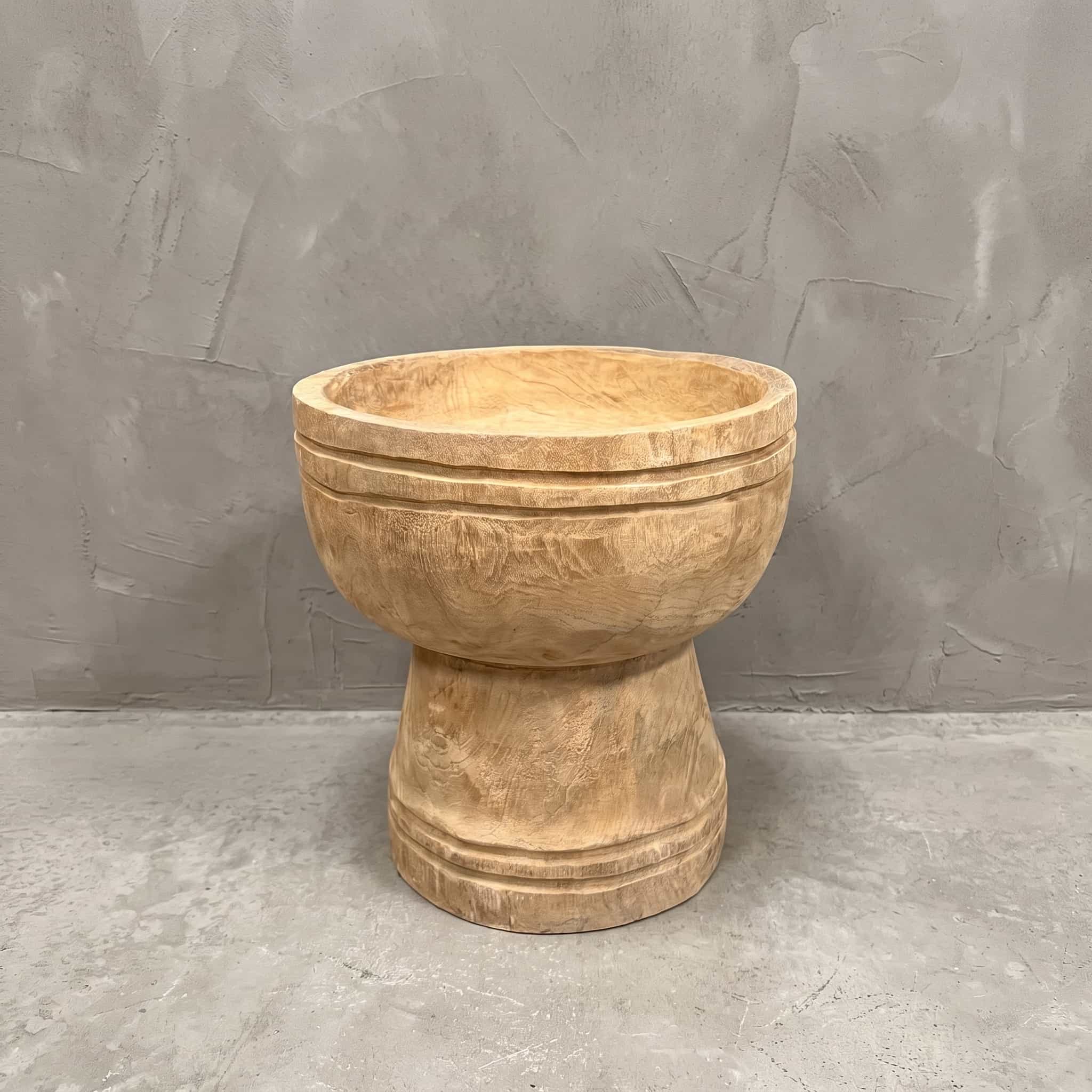 Pot Roots Ray van gerecycled teak, vooraanzicht van de ronde kom op een voet tegen een grijze wand