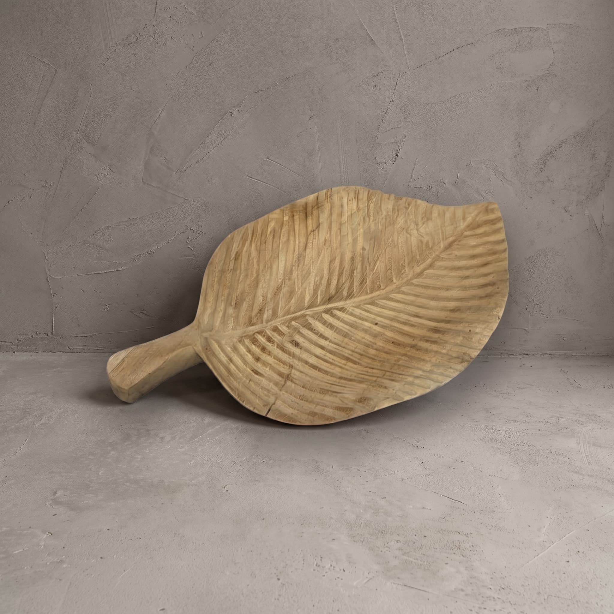 Bladvormige fruitschaal van gerecycled teak, 40 cm, vooraanzicht van de groeven en de steel, tegen een grijze wand