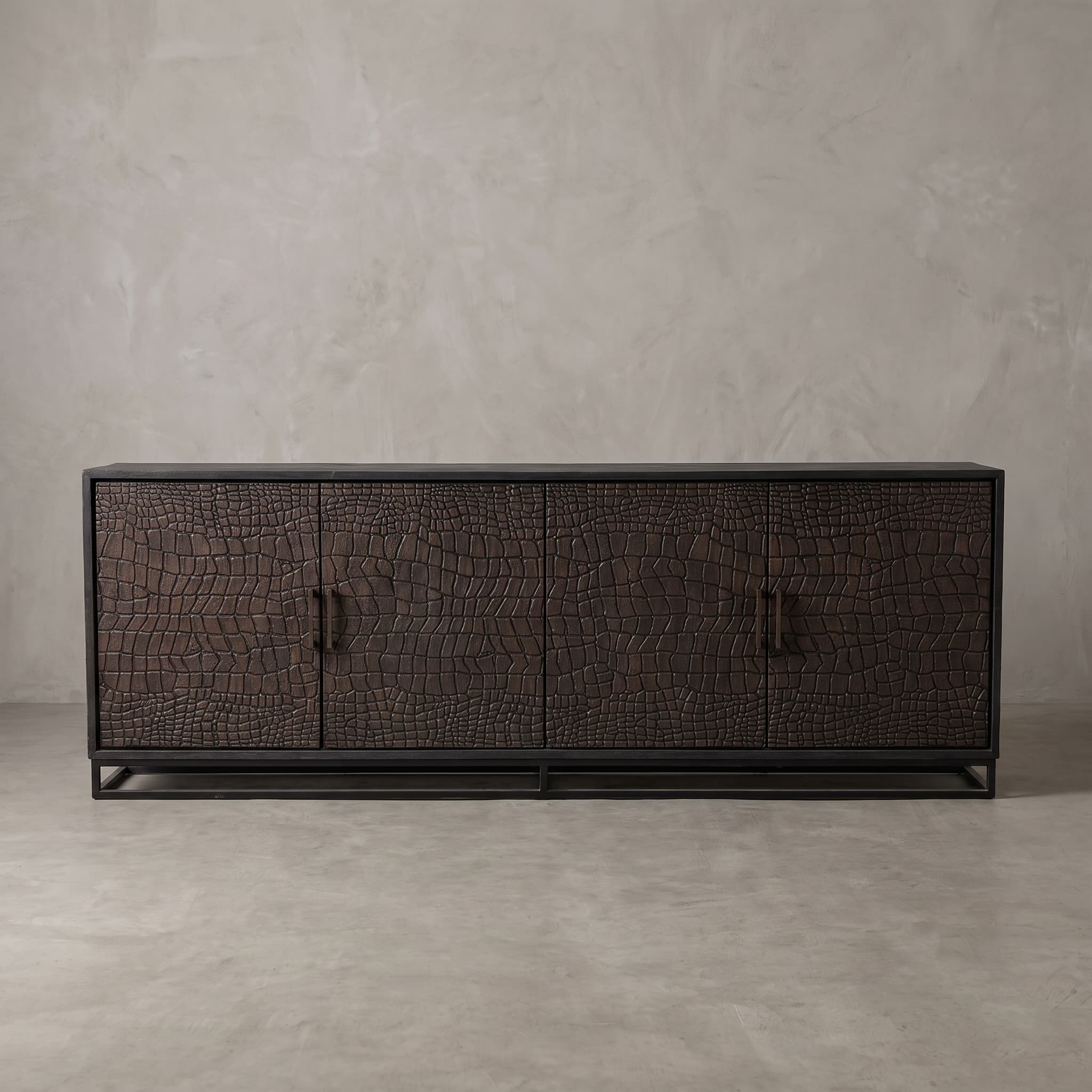 Sideboard Croco aus Teak, Vorderansicht: vier dunkelbraune Türen mit Schuppen im Relief, in schwarzem Rahmen auf offenem Gestell