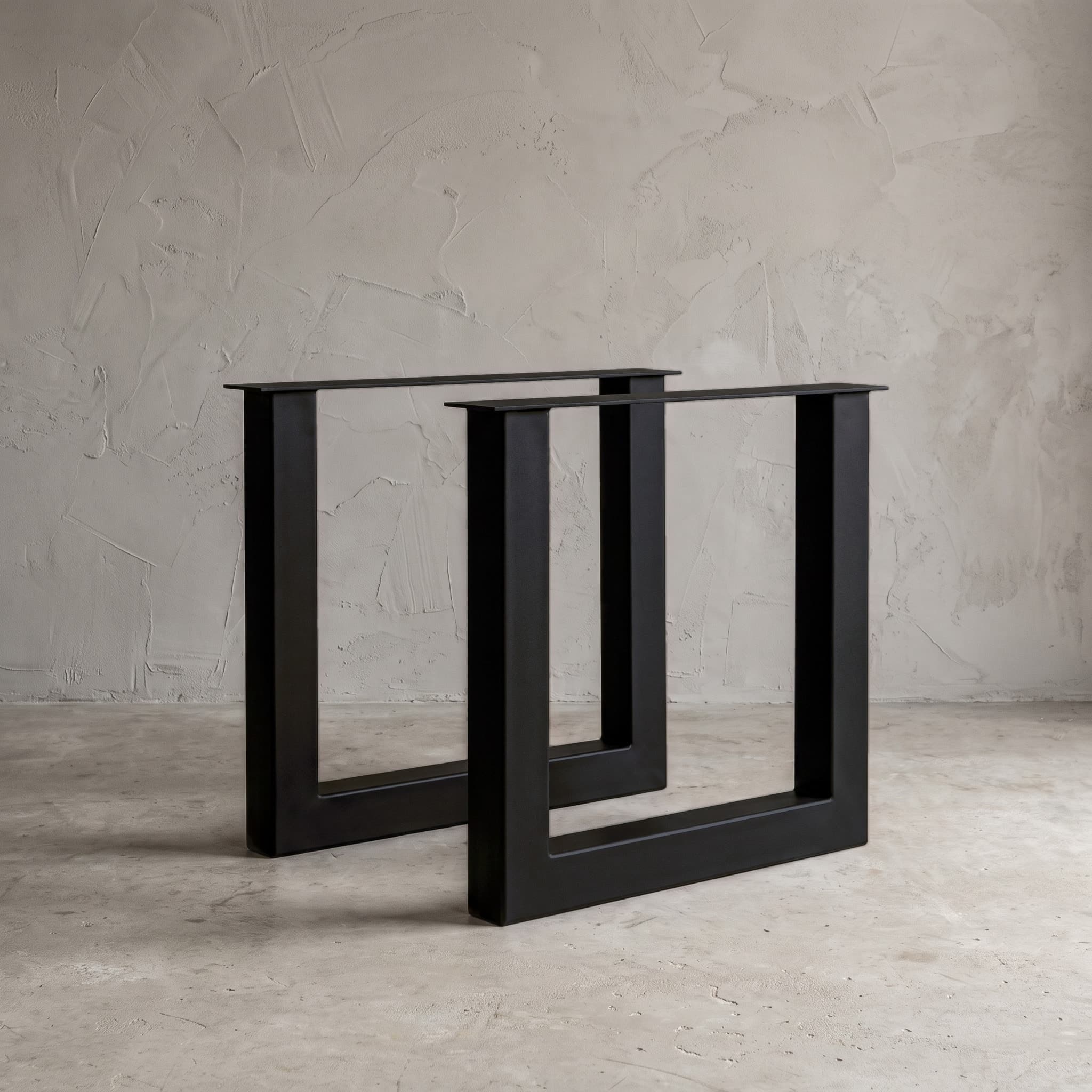 Onderstel U van metaal, gepoedercoat stalen tafelonderstel in Jet Black Fine Texture, schuin vooraanzicht met een tweede frame ernaast