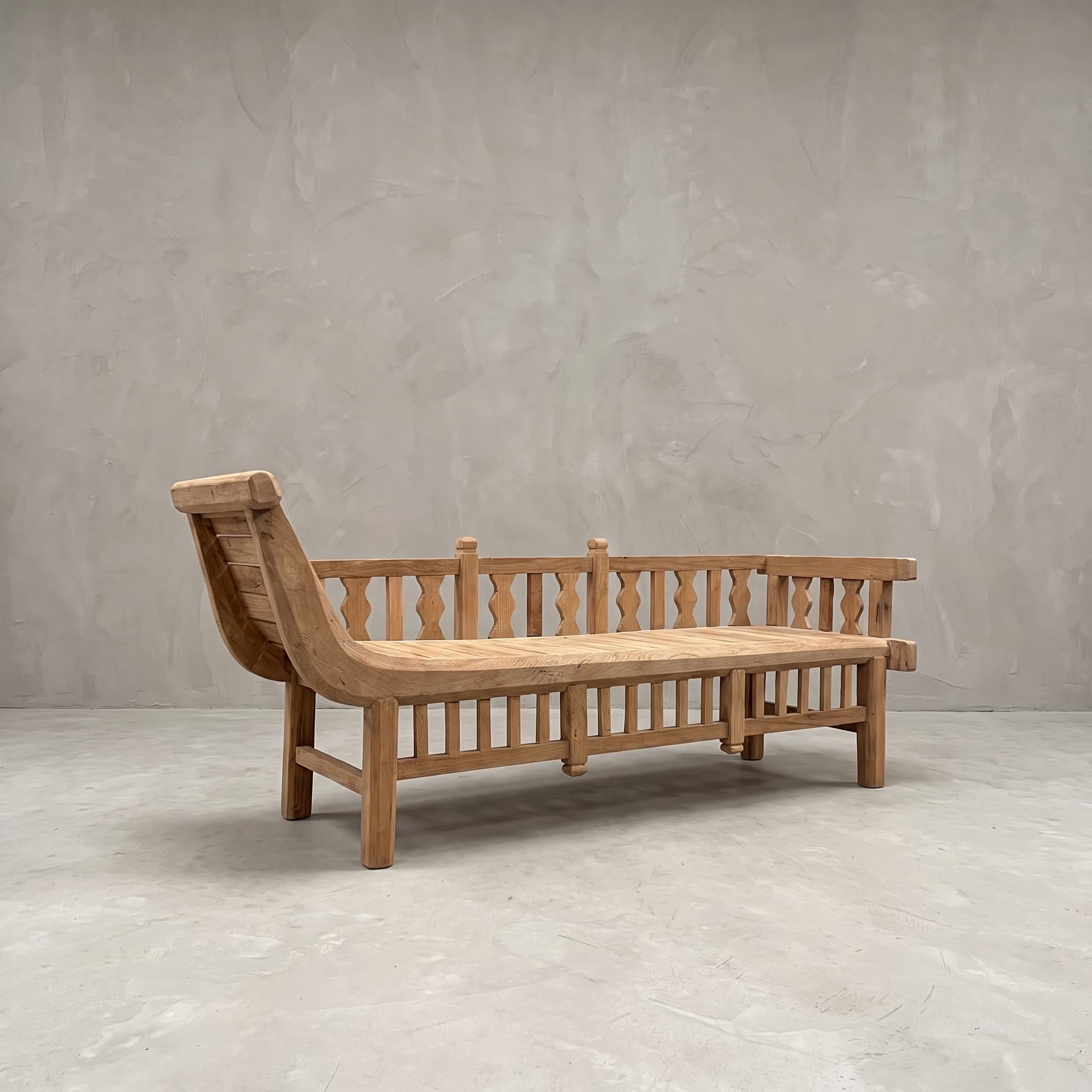 Bank Java Daydream van teak, schuin vooraanzicht met het gebogen hoofdeinde en de rugleuning met balusters