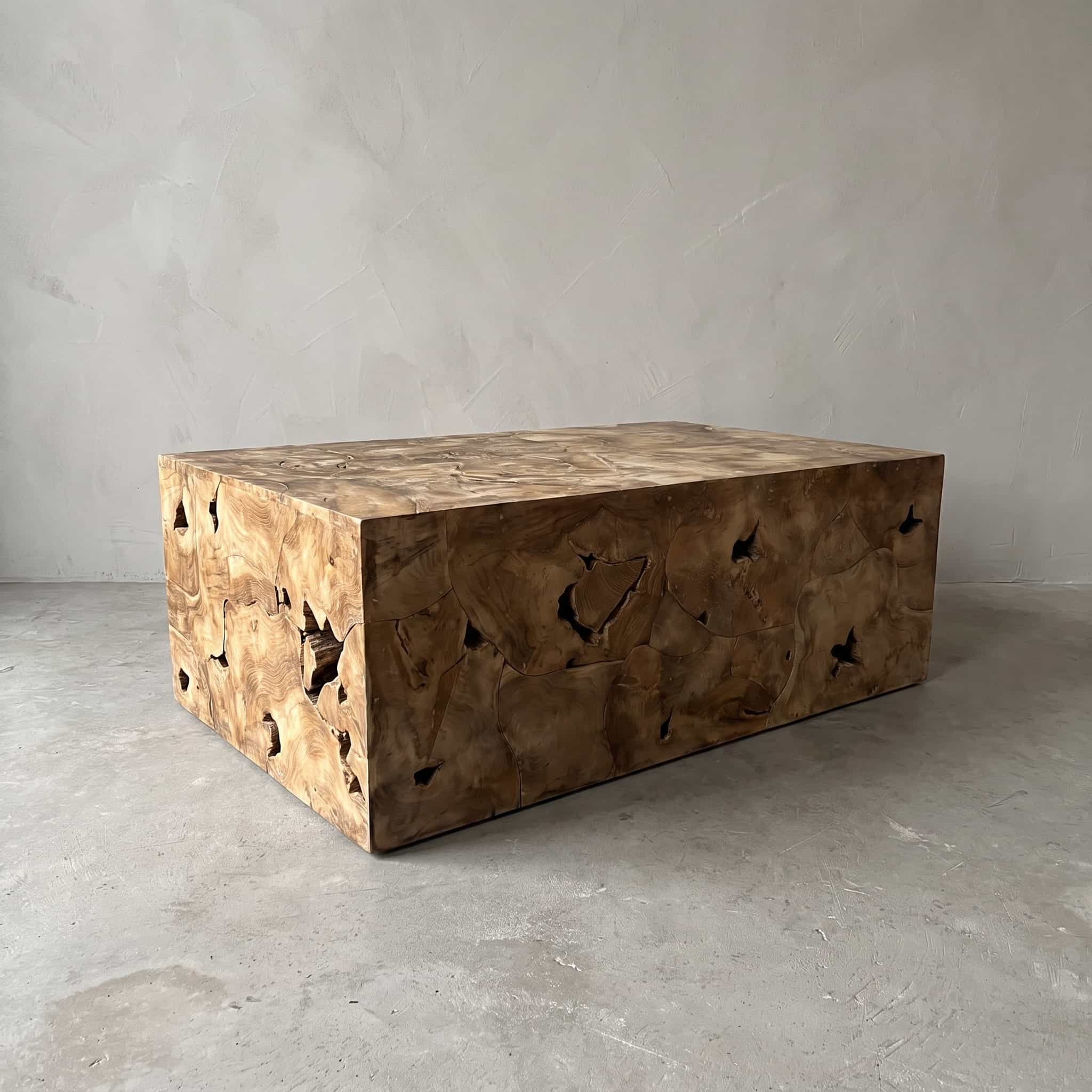 Salontafel Pandu van teak, rechthoekig, schuin vooraanzicht van de blokvorm met donkere holtes in de zijkanten