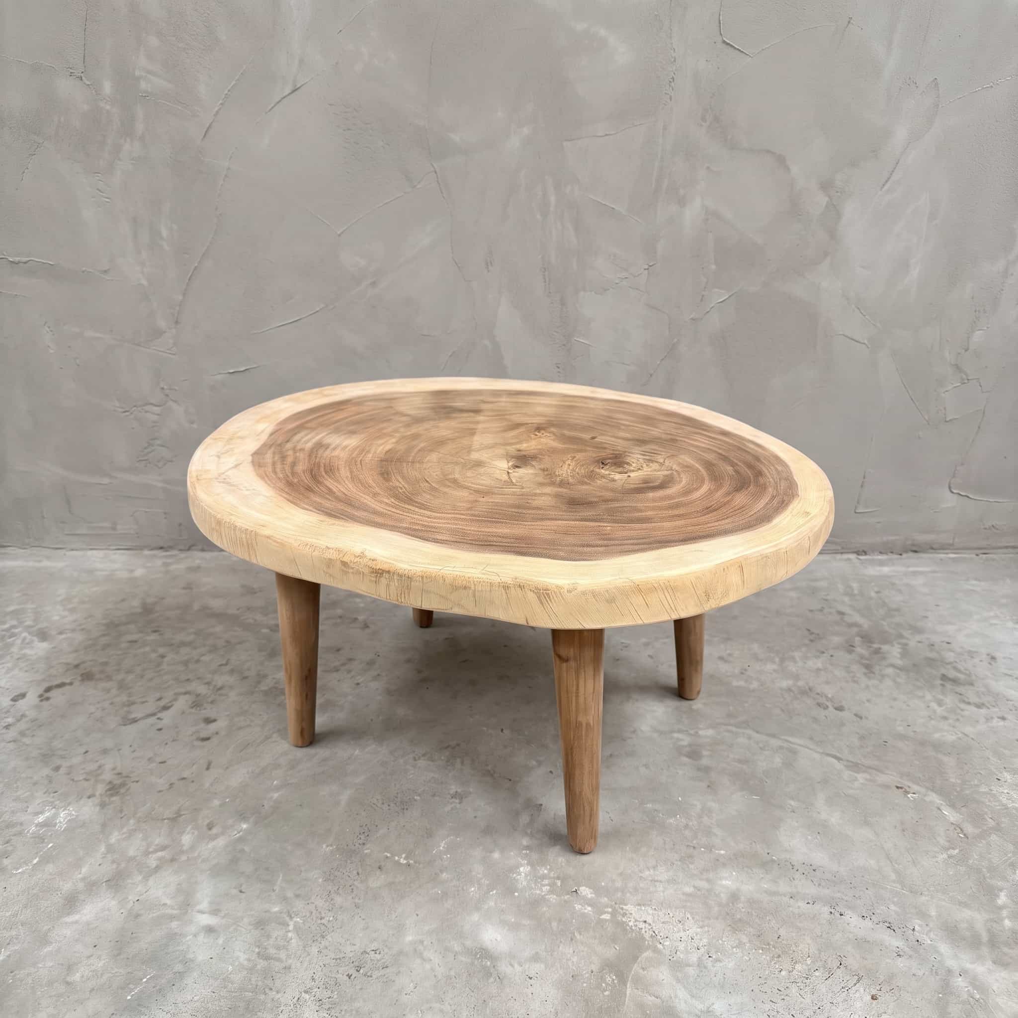 Salontafel van suarhout, met houten poten, 80 cm, schuin vooraanzicht van de ronde boomschijf met jaarringen en een lichte rand