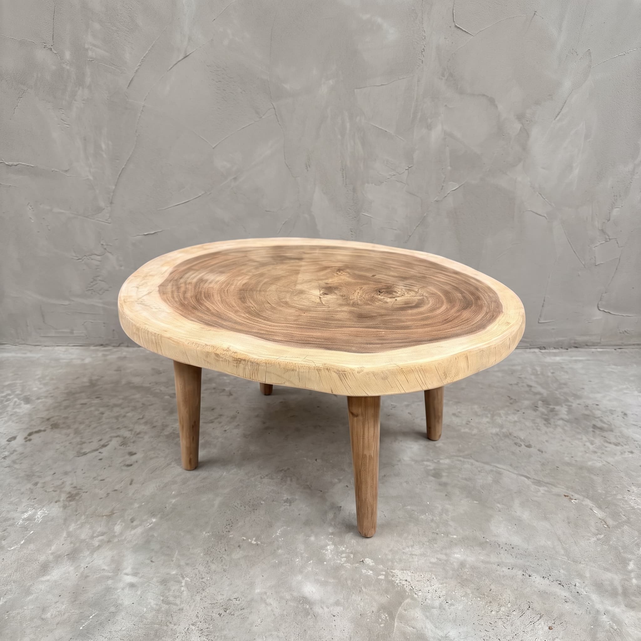 Salontafel van suarhout, met houten poten, 80 cm, schuin vooraanzicht van de ronde boomschijf met jaarringen en een lichte rand