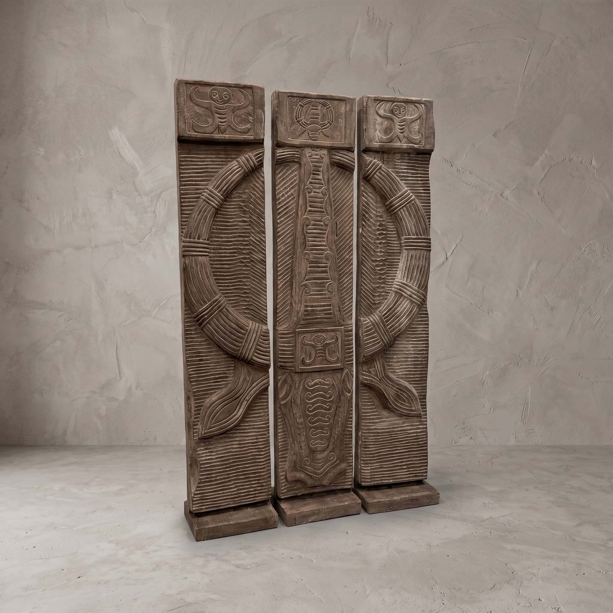 Roomdivider Toraja van suarhout schuin van links, met de fijne groeven naast de ring en de voeten onderaan