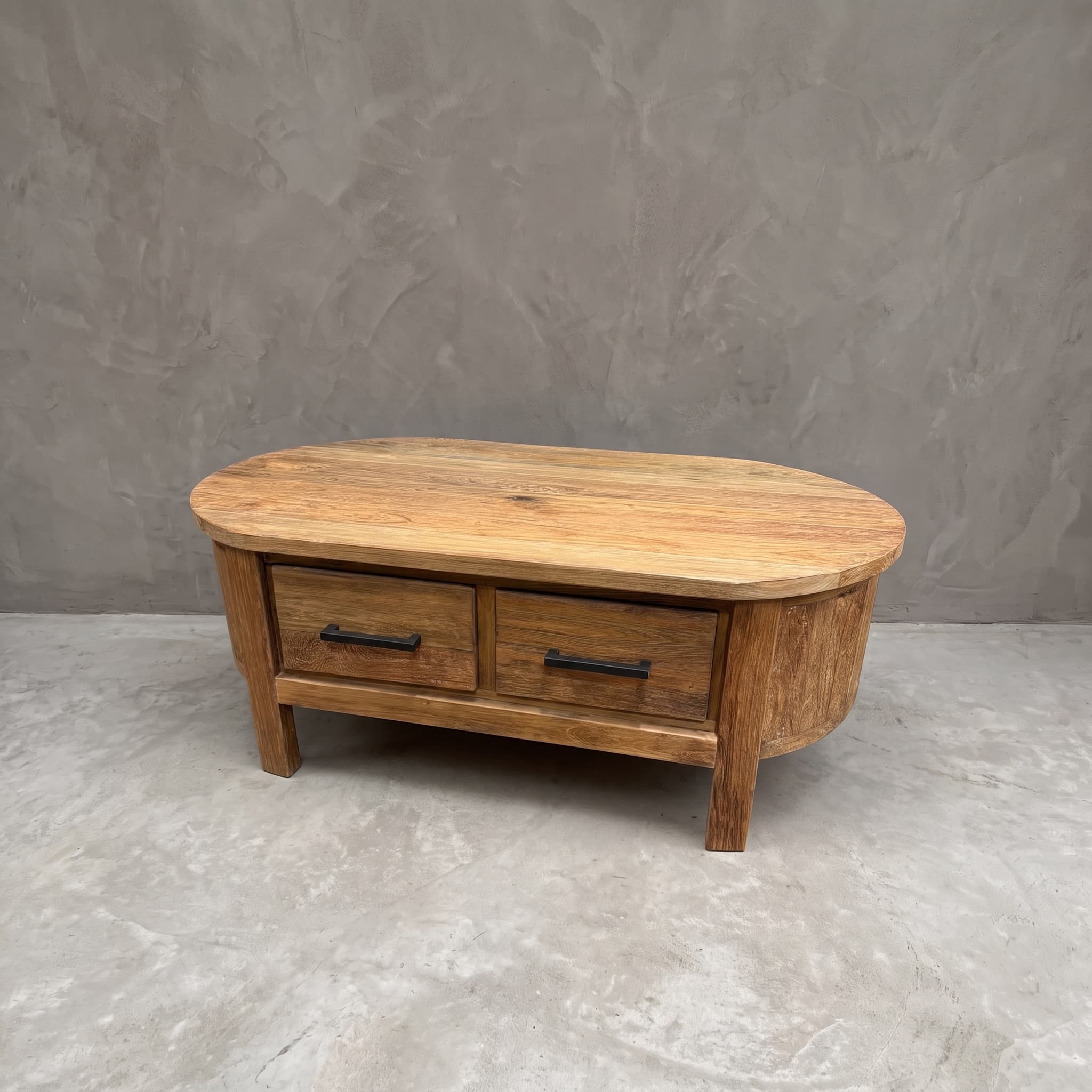 Salontafel Kira van gerecycled teak en metaal, schuin vooraanzicht met twee lades en een blad met afgeronde uiteinden