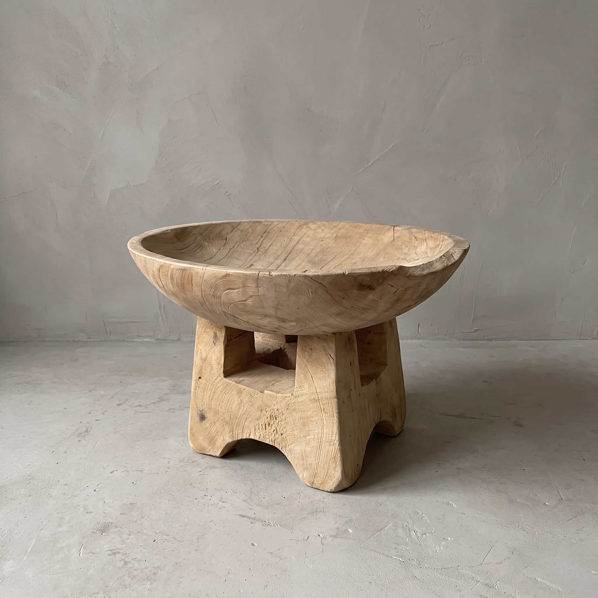 Fruitschaal van gerecycled teak, vooraanzicht van de ronde kom op de blokvormige voet, voor een grijze wand