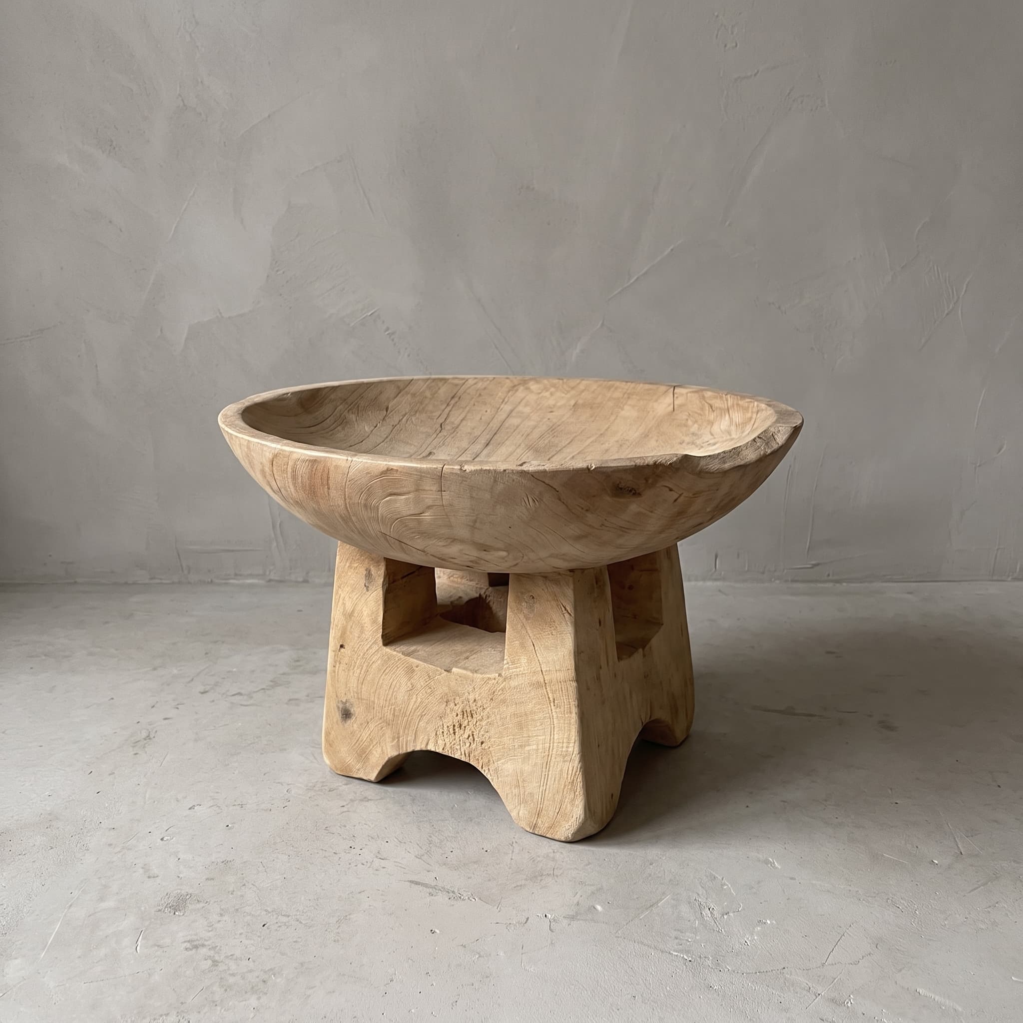 Fruitschaal van gerecycled teak, vooraanzicht van de ronde kom op de blokvormige voet, voor een grijze wand