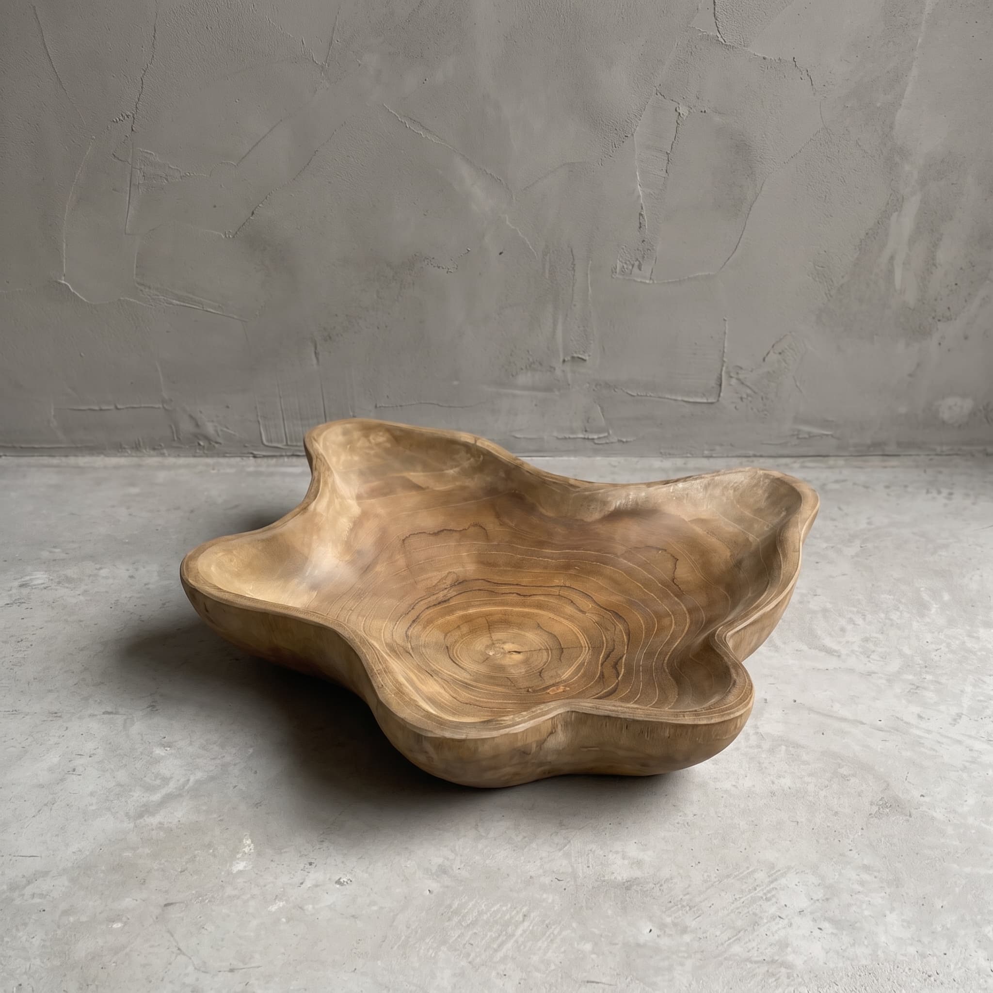 Rama reclaimed teak bowl, angled top view showing the annual rings in the base and the wavy rim, on a grey floor